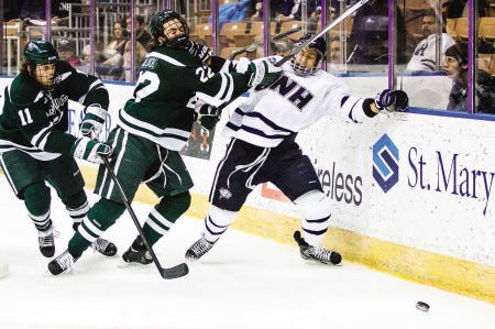 University of New Hampshire’s Dan Correale (right) battles against Ryan Bullock (center) and Eric Neiley (left) during last Saturday’s hockey game at the Verizon Wireless Arena in Manchester. UNH hosts Union in games tonight and Saturday.