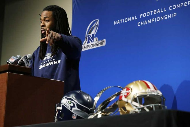 Seattle Seahawks cornerback Richard Sherman talks to reporters, Wednesday, Jan. 15, 2014, before NFL football practice in Renton, Wash. The Seahawks will play the San Francisco 49ers Sunday in the NFC championship. (AP Photo/Ted S. Warren)