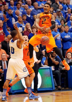 Oklahoma State guard Le'Bryan Nash (2), covered by Kansas guard Frank Mason (0), mishandles the ball while trying for a last second shot during the second half of an NCAA college basketball game at Allen Fieldhouse in Lawrence, Kan., Saturday, Jan. 18, 2014. Kansas defeated Oklahoma State 80-78. (AP Photo/Orlin Wagner)