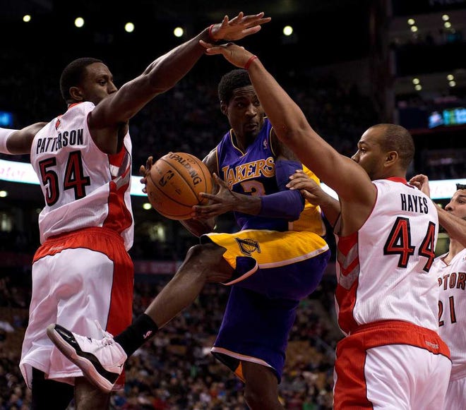 Los Angeles guard Manny Harris (3) tries to pass the ball as he drives between Toronto forwards Patrick Patterson (54) and Chuck Hayes (44) on Sunday in Toronto. The Lakers won, 112-106.