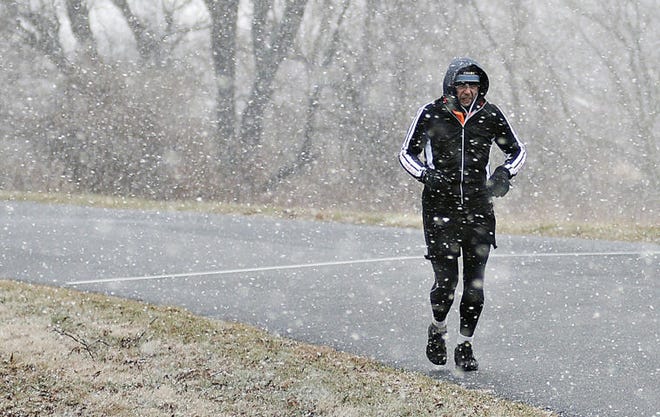 Vlad Rafalovitch is met with a wintery mix as he jogs through Tyler State Park in Newtown Township Saturday. The temperatures are expected to fall this coming week.