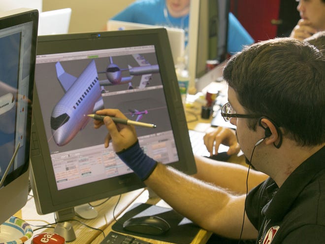 In this Nov. 13, 2013 file photo, artist Michael Swarts works on 3D art as the team prepares the next mobile game at Seven Gun Games in Ocala.