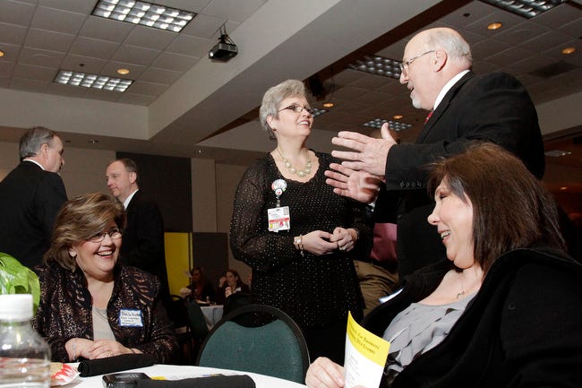 Background: Jonathan King (right), outgoing chairman of the Board of Directors, speaks with Tammy Gilland, banquet committee chair. Foreground: Sheila Hunter (left), minister First Christian Church in Watkinsville and Chamber member, speaks with Lisa King (right), wife of Jonathan King, during the Oconee County Chamber of Commerce members banquet and annual meeting in Watkinsville, Ga., on Thursday, Jan. 23, 2014. The crowd of more than 340 people is the largest ever for the event.(David C Bristow/Staff)