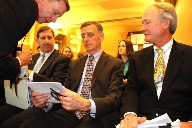 Kevin Flynn, Rhode Island associate planning director, leans in to a conversation including Neil Steinberg, of the Rhode Island Foundation, left, Marcel Valois, of the Rhode Island Commerce Corporation, center, and Governor Chafee.