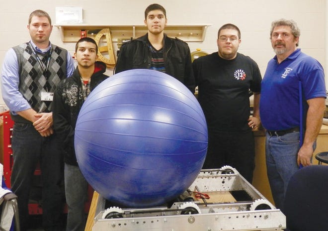 Boys and Girls Club of Fitchburg and Leominster Teen Center director Jon Blodgett, team mentor Jake Janssens, member Clever Chaves, member Jonathan Vega, and team advisor Steve McNamara work hard on the robot that they will submit.