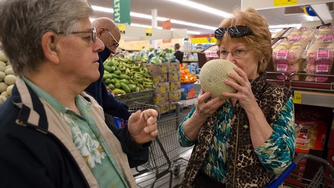 Shirley Clark, right, of Virginia, smells a cantaloupe to tell her brother Wayne Sparks, left, of Lake Worth, if it is ripe during the opening of the new Aldi store in Palm Springs on Thursday, January 23, 2014. The store plans to hold tastings and a barbecue to celebrate their first day of being open to the public. (Madeline Gray/The Palm Beach Post)