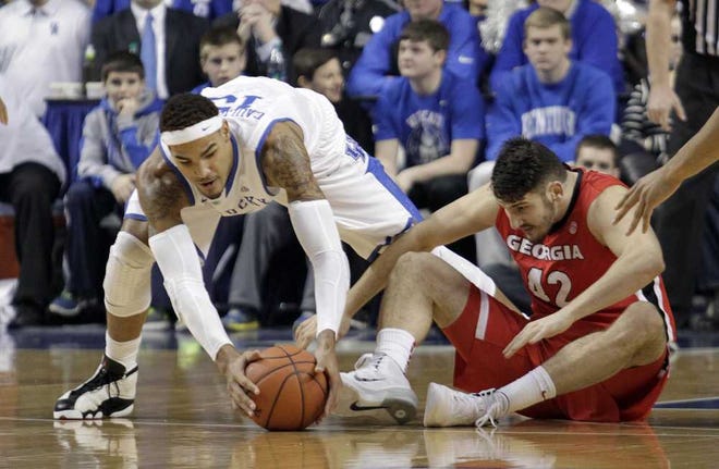 Kentucky's Willie Cauley-Stein, left, gathers up a loose ball next to Georgia's Nemanja Djurisic during the first half of an NCAA college basketball game, Saturday, Jan. 25, 2014, in Lexington, Ky. (AP Photo/James Crisp)
