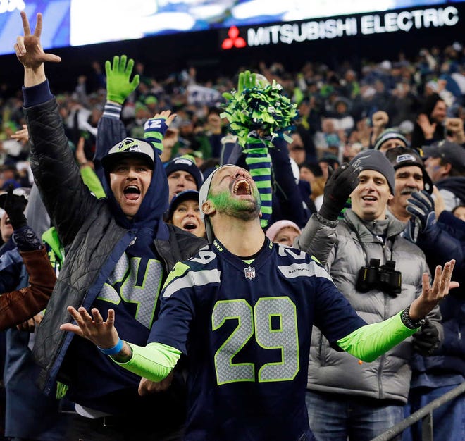 ADVANCE FOR WEEKEND EDITIONS, JAN. 25-26 - In this Jan. 19, 2014, file photo, Seattle Seahawks fans celebrate a Seahawks touchdown run by Marshawn Lynch during the second half of the NFC championship NFL football game against the San Francisco 49ers in Seattle. The last time one of Seattle's major franchises had a parade to celebrate a title, no one on the Seahawks roster was born. To call Seattle's championship history thin is an understatement. Maybe that's why there's so much support behind these Super Bowl-bound Seahawks. (AP Photo/Elaine Thompson, File)
