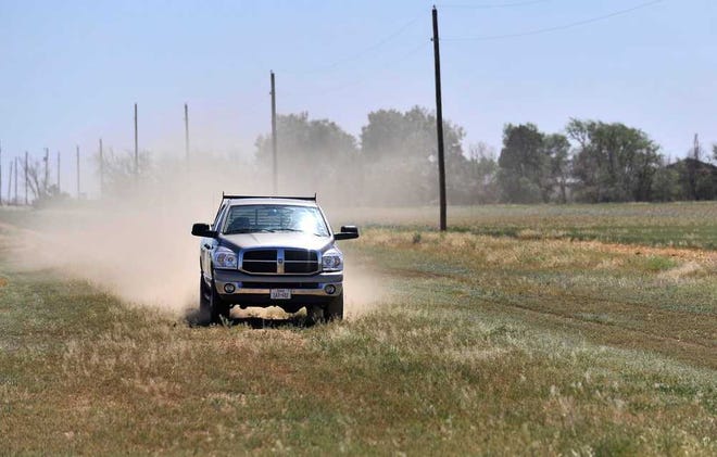 An area farmer creates a cloud of red dirt behind his vehicle April 27, 2012, in south Amarillo. Amarillo and the surrounding area are still suffering through record breaking drought conditions.