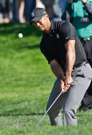 Tiger chips to the second green on the South Course at Torrey Pines where he bogeyed during the third round of the Farmers Insurance Open golf tournament Saturday, Jan. 25, 2014, in San Diego. (AP Photo/Lenny Ignelzi)