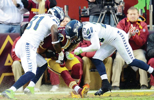 Washington Redskins running back Evan Royster (22) scores on a touchdown catch between Seattle Seahawks strong safety Kam Chancellor (31) and Seahawks free safety Earl Thomas (29) in the first quarter of an NFC wild-card playoff game on January 6, 2013. (MCT)