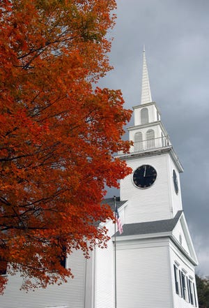 The changing leaves of a tree contrast against the Grace Bible Church in East Bridgewater on Tuesday.