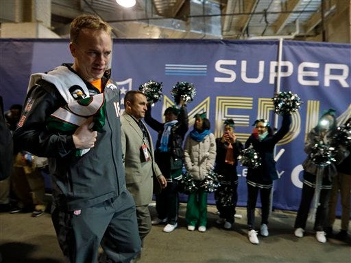 Denver Broncos' Peyton Manning walks past some cheerleaders as he leaves media day for the NFL Super Bowl XLVIII football game Tuesday, Jan. 28, 2014, in Newark, N.J.