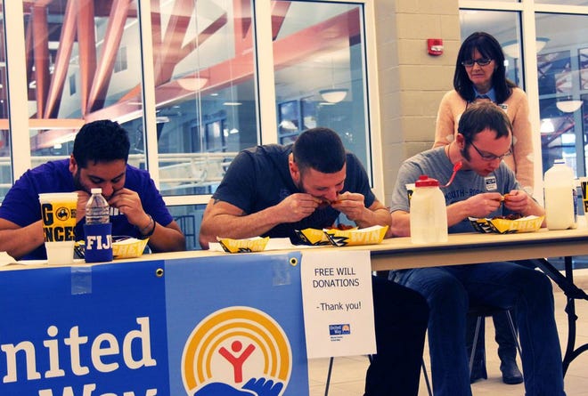 Contestants eat “Blazin’” hot wings from Buffalo Wild Wings as quickly as their mouths allow Saturday at Monmouth College’s Huff Athletic Center, as part of the Warren County United Way’s annual contest. The event raised close to $1,600. CASSANDRA BURTON/REVIEW ATLAS