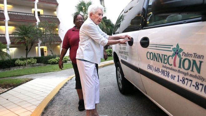 A Palm Tran Connection driver helps a woman get into the bus. Metro Mobility has drawn numerous complaints from its elderly and disabled riders since its contract started in August 2012. As part of its request to get out of the contract, the company is willing to continue until Jan. 31, 2015. (Palm Beach Post file photo)