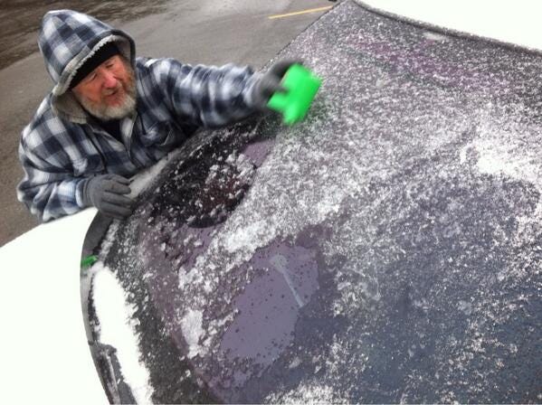 Gordon McCranie scrapes ice from his car at the Panama City Beach Walmart.