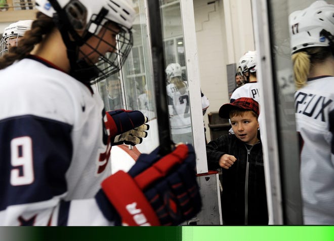 Ian Michelsen, 8, of Arlington gives members of the USA Women's Ice Hockey Team a fist bump as they walk off the ice after a scrimmage against the Boston Bandits at the Belmont Hill School on Wednesday afternoon. Team USA won the pre-Olympics practice game, 5-1.

Wicked Local Staff photo/David Gordon