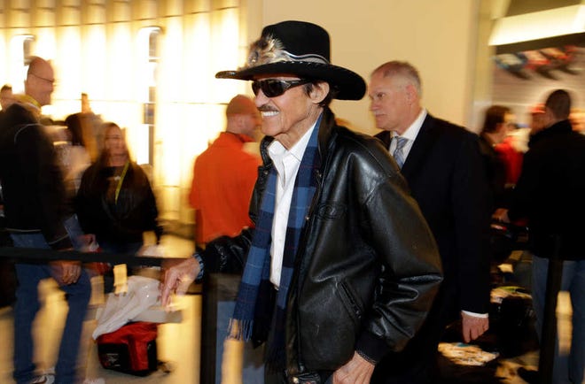 NASCAR Hall of Fame driver Richard Petty rushes by the crowd of fans on his way to the NASCAR Hall of Fame Induction Ceremony, Wednesday, Jan. 29, 2014, in Charlotte, N.C. (AP Photo/Bob Leverone)
