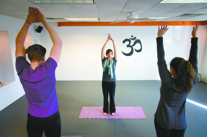 The mental concentration learned through yoga practice can help people recover from past trauma, says yoga teacher Petra Lehman, pictured at center.