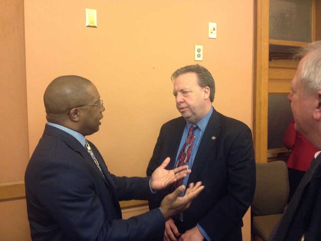 Terry Wright of GNB National Mortgage, left, talks to Sen. Tom Holland, D-Baldwin City, after Wednesday's hearing.