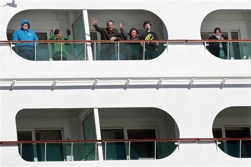 Passengers wave from the Explorer of the Seas cruise ship as it docks at a berth in Bayonne, N.J., Wednesday, Jan. 29, 2014. The number of passengers and crew reported stricken ill on the cruise ship has risen to nearly 700. The U.S. Centers for Disease Control and Prevention said Wednesday its latest count puts the number of those sickened aboard the Explorer of the Seas at 630 passengers and 54 crew members. (AP Photo/Mel Evans)