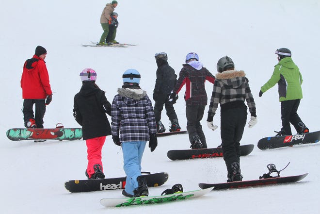 Novice snowboarders get a lesson from instructor Patrick Burke at Yawgoo Valley on Jan. 10.