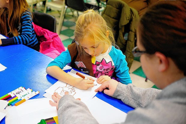 Madison Crissinger, 8, draws a picture with her mom Jennifer Ball, right, to be used on a blanket for the Linus Project.