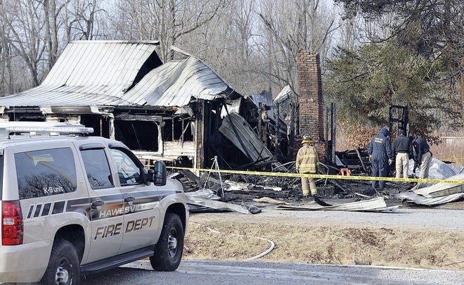 Members of the Kentucky State Fire Marshall’s office look over the remains of a house fire in Depoy, Ky., on Thursday. AP PHOTO/TIMOTHY D. EASLEY