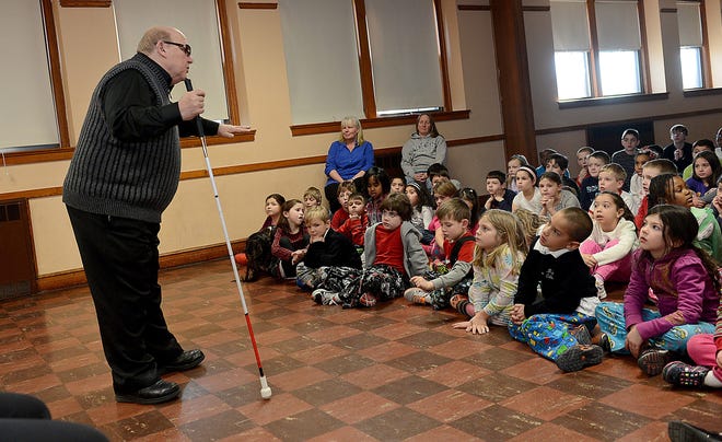 Michael Cataruzolo, the coordinator of volunteer services for the Perkins School for the Blind in Watertown, speaks to students at the Milford Catholic Elementary School Thursday. Daily News Staff Photo/Ken McGagh
