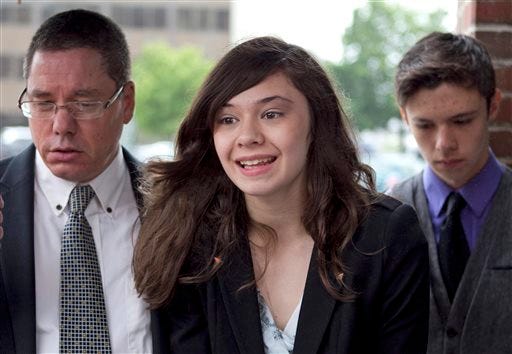 Transgender student Nicole Maines, center, with her father Wayne Maines, left, and brother Jonas, is seen in 2013 speaking to reporters outside the Penobscot Judicial Center in Bangor, Maine. The Maine Supreme Judicial Court ruled Thursday that Nicole Maines should have been allowed to use the bathroom of her choice in 2009 after school officials required her to use a staff bathroom instead of the girls' restroom.
