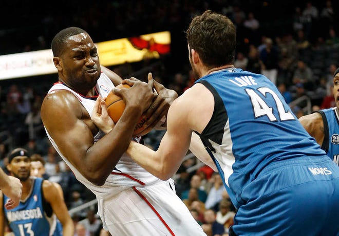 Atlanta forward Elton Brand and Minnesota's Kevin Love (right) fight for a rebound during the first half Saturday night. The Hawks had to overcome Love's 43 points for the win.