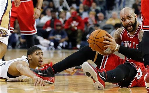 Chicago Bulls forward Carlos Boozer (5) grabs a loose ball in front of New Orleans Pelicans forward Anthony Davis during the second half of an NBA basketball game in New Orleans, Saturday, Feb. 1, 2014. The Pelicans defeated the Bulls 88-79. (AP Photo/Bill Haber)