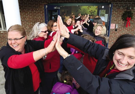 The entire staff at Horace Mitchell Primary School in Kittery Point, Maine, including Michelle Perry, left, and Dana Rickerich, put their hands together at the entrance of the school to welcome their 400 students into the building Friday morning as part of The Great Kindness Challenge.
