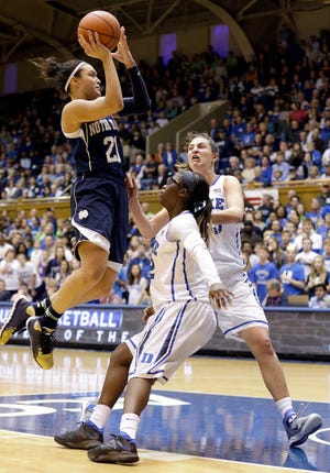 Notre Dame's Kayla McBride (21) drives to the basket as Duke's Alexis Jones and Haley Peters, right, defend during the second half of an NCAA college basketball game in Durham, N.C., Sunday, Feb. 2, 2014. Notre Dame won 88-67. (AP Photo/Gerry Broome)
