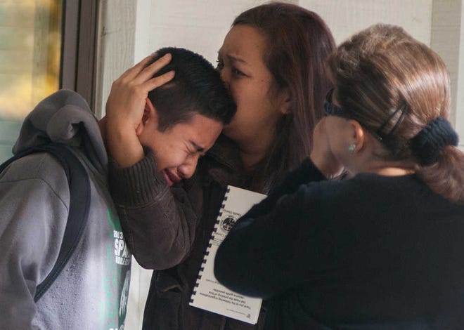 A Sparks Middle School student is comforted as he cries after being released from Agnes Risley Elementary School, where some students were evacuated after a shooting, in Sparks, Nev.