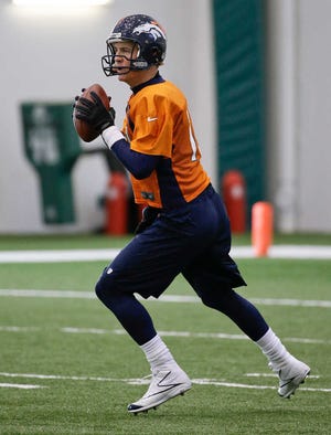 Denver quarterback Peyton Manning drops back to pass during practice Thursday in Florham Park, N.J.