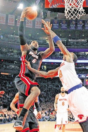 Heat's LeBron James goes to the basket against the Knicks' J.R. Smith in the first half.