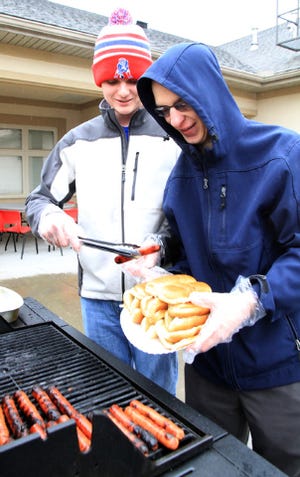 Jamie Mitchell • Times Record - Stephen Roberts, left, and Connor Schmidt make hot dogs Saturday, Feb. 1, 2014, during First Lutheran Church's "1st Saturday Lunch," on the North D Street church patio. Roberts said that the once-monthly lunch includes chips and dessert for anyone who shows up and is part of First Lutheran's community outreach programs.