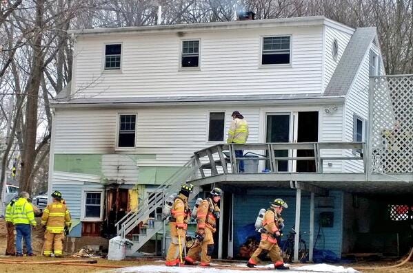Eliot and Kittery firefighters overhaul the back of the residence at 175 Hansom Road on Monday.
