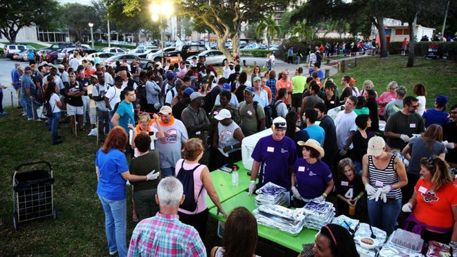 A line forms for hot meals during a Super Bowl party for the homeless at First Baptist Church Chapel by the Lake in West Palm Beach.
