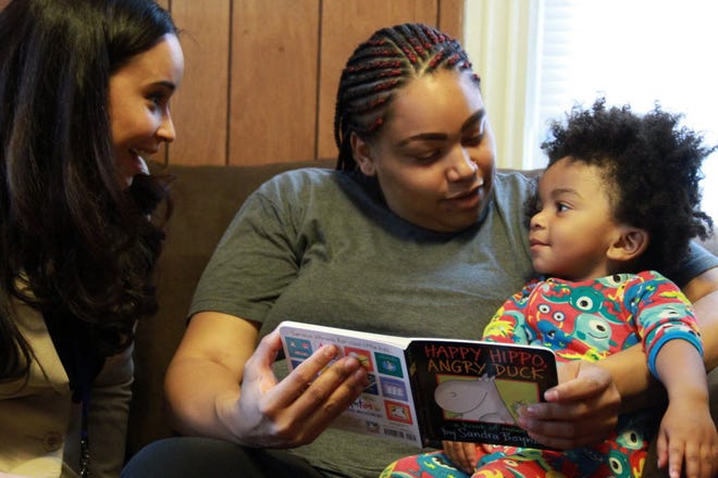 Stephanie Taveras, home visitor with Providence Talks, provides a book and some specific suggestions for mom Ashley Cox on how best to involve Jaiden, 16 months, with the reading experience.