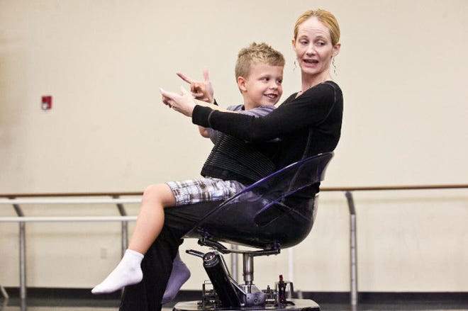University of South Florida dance professor Merry Lynn Morris shows George Elliott, 5, how to move her electronic dance wheelchair with his body during a mixed-ability dance class in Tampa.