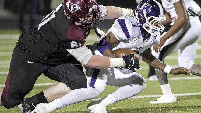 Bastrop’s Jordan Davis wraps up Elgin’s Anthony Nash during a Class 17-4A matchup in October. The teams will go their separate ways next fall as a result of UIL realignment. Bastrop will join a group of Austin schools in District 26-5A, and Elgin will move to 17-5A, which includes Temple and two Waco high schools.