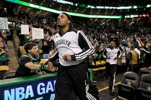 Brooklyn Nets forward Paul Pierce, front, formerly of the Boston Celtics, receives applause as he steps onto the court before an NBA basketball game against the Celtics, Sunday, Jan. 26, 2014, in Boston.