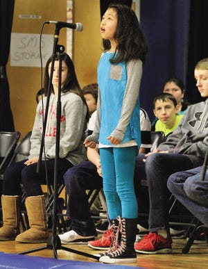 Jihour Kim a fifth-grader at the Seabrook Middle School stands at a microphone to spell out a word during the school's annual Spelling Bee on Friday.
Rich Beauchesne photo