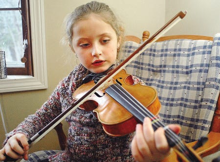Rutherford, 7, takes violin lessons in a class taught by Lynne McMahon Wednesday mornings at Village Elementary School.