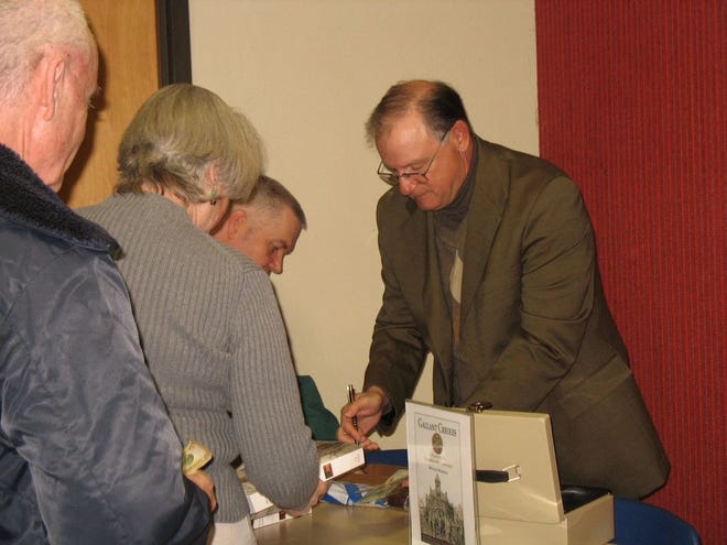 Author Michael Marshall signs his book for readers at the Ascension Parish Library on Jan. 23.