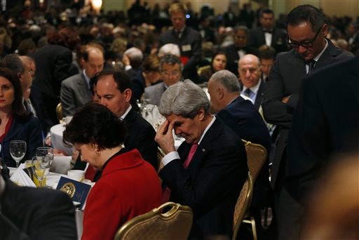 Secretary of State John Kerry, center, bows his head with other attendees at the National Prayer Breakfast which was also attended by President Barack Obama in Washington, Thursday, Feb. 6, 2014. (AP Photo/Charles Dharapak)