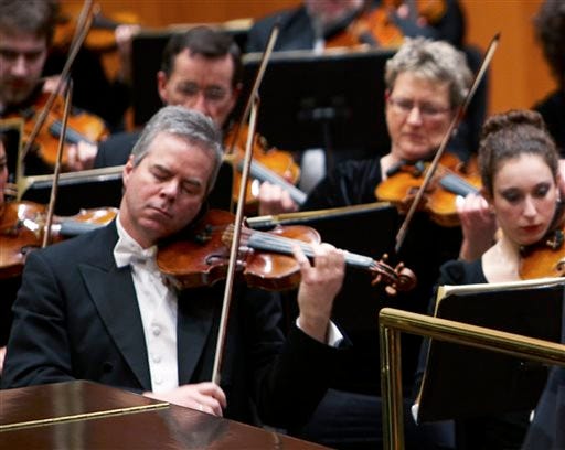 In this undated photo provided by the Milwaukee Symphony Orchestra concertmaster Frank Almond plays a 300-year-old Stradivarius violin that was on loan to him during a concert in Milwaukee. Police said Wednesday, Feb. 5, 2014, three people have been arrested in connection with the theft of the multi-million-dollar instrument.
