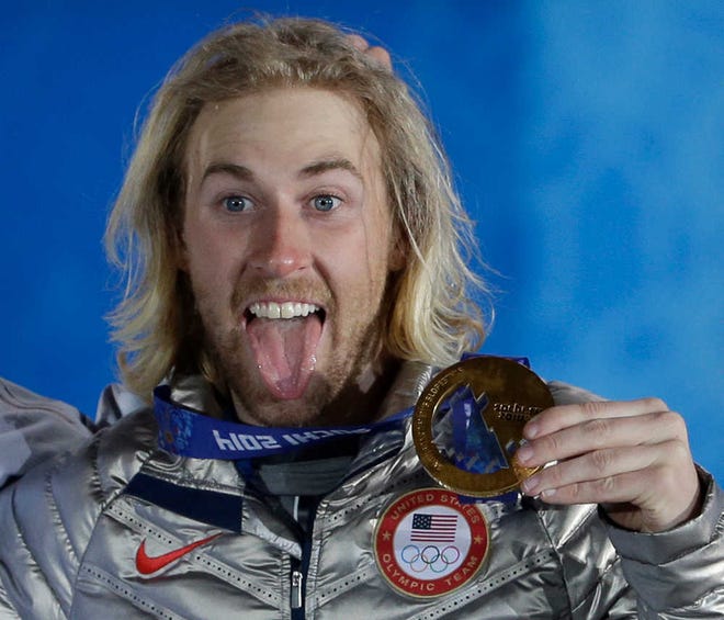 Gold medal winner Sage Kotsenburg, of the United States, holds up his medal during the medal ceremony for the Snowboard Men's Slopestyle competition at the 2014 Winter Olympics, Saturday, Feb. 8, 2014, in Sochi, Russia. (AP Photo/David J. Phillip )